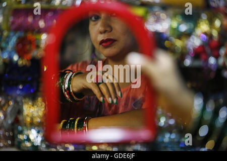 Katmandou, Népal. 16 juillet, 2016. Une Népalaise femme regarde un miroir essayer bangles le premier jour du mois sacré hindou de Shrawan à Indra Chowk, Katmandou, Népal le samedi 16 juillet, 2016. Ce mois est considéré comme de bon augure et célébrée pour la longue vie de mari et de l'accomplissement de son désir et prospère pour les familles. © Skanda Gautam/ZUMA/Alamy Fil Live News Banque D'Images