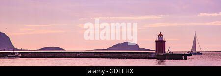 Voilier naviguant par Phare et de la jetée. Alesund, Norvège, More og Romsda, Scandinavie, l'Europel Banque D'Images