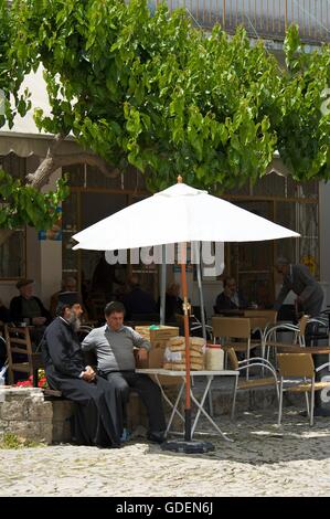 Un moine assis dans un café de la rue, les montagnes de Troodos, République de Chypre Banque D'Images