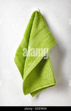 Green spa accroché sur une serviette de bain blanche wall background Banque D'Images