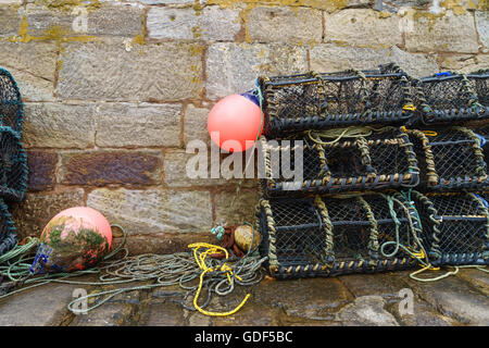 Des casiers à homard (nasse) sur un ancien mur du port en Ecosse. Banque D'Images