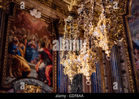 Chapelle Igreja de Sao Roque Saint Jean Baptiste Or lanternes argentées Lisbonne Portugal | LISBONNE, Portugal — des lanternes suspendues dorées et argentées dominent le premier plan de la Capela de São João Baptista à l'Igreja de São Roque, avec une scène de Pentecôte peinte visible derrière. Le roi João V commanda la chapelle, construite à Rome entre 1742 et 1747 par les architectes Nicola Salvi et Luigi Vanvitelli en utilisant la richesse de l'or brésilien, puis la fit démanteler et expédier à Lisbonne, où elle fut remontée et inaugurée en 1750. Ses scènes d'autel sont exécutées en micro-mosaïque plutôt qu'en peinture. Banque D'Images