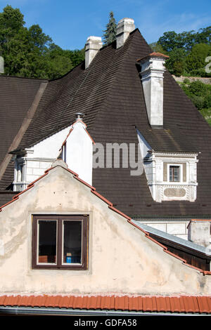 Toit en tuiles historiques à lucarnes et la cheminée contre le ciel bleu Banque D'Images