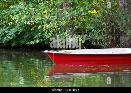 Chaloupe rouge sur la rive d'un lac Banque D'Images