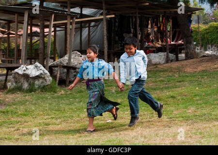 Les enfants courent, main dans la main, San Lucas Toliman, Lago de Atitlan, Guatemala, Amérique Centrale Banque D'Images