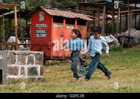 Les enfants courent, main dans la main, San Lucas Toliman, Lago de Atitlan, Guatemala, Amérique Centrale Banque D'Images