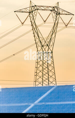 Pylône haute tension et bleu vert panneaux photovoltaïques Banque D'Images