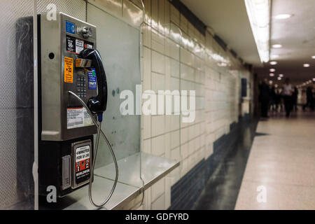 Téléphone public payant dans un des couloirs de la station de métro du Rockefeller Center à New York City Banque D'Images