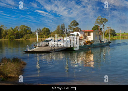 Traversier pour véhicules avec camions & voitures à bord crossing & reflète dans les eaux calmes de la rivière Clarence bleu sous ciel bleu dans le NSW Australie Banque D'Images