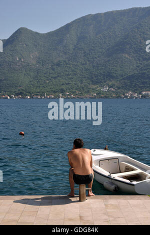 L'homme assis à la rive à Perast, Monténégro Banque D'Images