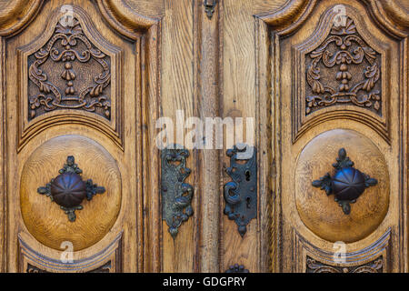 Double porte en bois sculpté avec un ancien verrou sur une maison à Fribourg, Suisse Banque D'Images
