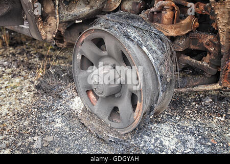 Burnt Out chariot abandonnées sur un terrain commun. C'est le reste de la roue de voiture après le pneu a été brûlé pour rien Banque D'Images