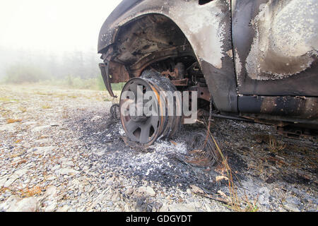 Burnt Out chariot abandonnées sur un terrain commun. C'est le reste de la roue de voiture après le pneu a été brûlé pour rien Banque D'Images