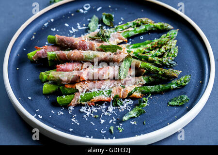 Asperges grillées enveloppé dans du jambon de Parme avec du parmesan, sauge et thym Banque D'Images