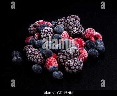 Les fruits des bois, framboises, bleuets et mûres sur une table en pierre noire Banque D'Images