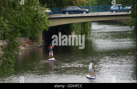 Berlin, Allemagne. 11 juillet, 2016. Deux stand up paddleboarders vous promener le long du canal Landwehr à Berlin, Allemagne, 11 juillet 2016. Le quartier branché de sport paddleboarding standup, dans lequel on se déplace dans l'eau debout, a frappé les eaux de Berlin. Photo : PAUL ZINKEN/dpa/Alamy Live News Banque D'Images