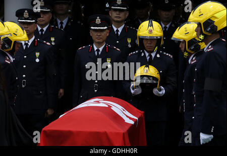 Hong Kong, une police officielle avec honneur funèbre a eu lieu ici dimanche pour Thomas Cheung. 25 Juin, 2016. Un collègue de Thomas Cheung est titulaire d'un casque utilisé par Thomas lors de ses funérailles tenues à l'Universel Funérarium dans Hung Hom à Hong Kong en Chine du sud, le 17 juillet 2016. Un enterrement officiel de la police avec un honneur a eu lieu ici dimanche pour Thomas Cheung, 30 ans, agent principal de la gare qui est mort en combattant un incendie dans un bâtiment industriel à Hong Kong Kowloon East le 25 juin 2016. © Ng Wing Kin/Xinhua/Alamy Live News Banque D'Images