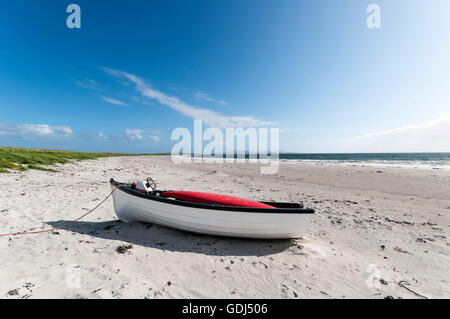 Bateau sur une plage déserte près de Gearraidh Hebridean na Monadh sur South Uist. Banque D'Images