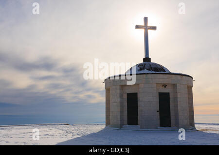 Cristian traverser une petite église avec soleil en contre-jour. Panorama d'hiver italien Banque D'Images