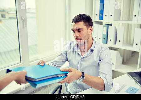 Businessman taking dossier à partir de l'office de secrétaire Banque D'Images