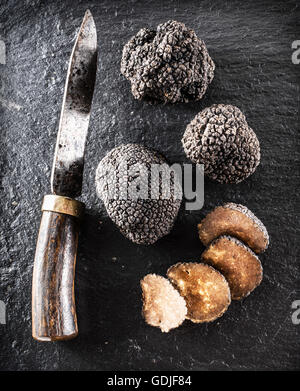 Truffes noires et truffes tranches sur le conseil de graphite. Banque D'Images