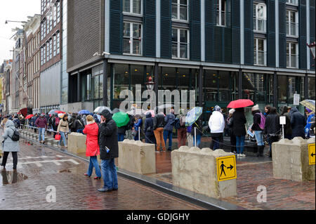 Les gens d'attente dans la pluie à l'extérieur du Musée d'Anne Frank à Amsterdam, Hollande, Pays-Bas. Banque D'Images