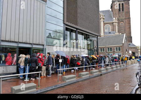 Les gens d'attente dans la pluie à l'extérieur du Musée d'Anne Frank à Amsterdam, Hollande, Pays-Bas. Banque D'Images