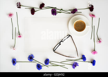 Papier, tasse de café et verres avec floral frame à partir de pétales de fleurs sur fond blanc. Vue de dessus. Mise à plat. Banque D'Images