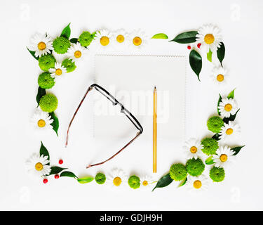 Papier, crayon et verres avec floral frame à partir de camomille et de fleurs de chrysanthème, ficus feuilles et ripe rowan sur white backg Banque D'Images