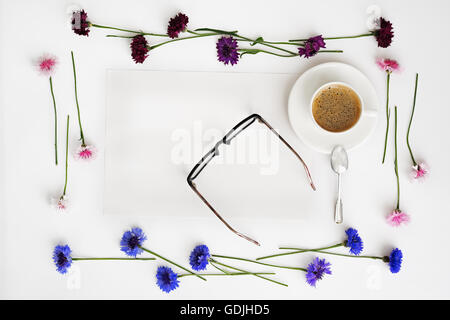 Papier, tasse de café et verres avec floral frame à partir de pétales de fleurs sur fond blanc. Vue de dessus. Mise à plat. Banque D'Images