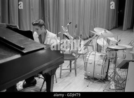 Elvis Presley consacre quelques pages au piano en attendant un spectacle pour démarrer à l'Université de Dayton Fieldhouse, le 27 mai 1956. Banque D'Images