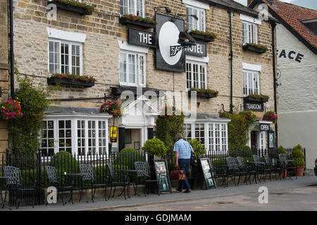 L'extérieur de l'établissement Black Swan Hotel, Helmsley, North Yorkshire - un homme entrer cette popular boutique hotel dans le centre historique de la ville de marché. Banque D'Images