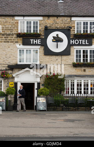 Entrée de l'établissement Black Swan Hotel, Helmsley, North Yorkshire - un homme sortant de ce populaire boutique hotel dans le centre historique de la ville de marché. Banque D'Images