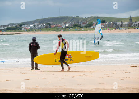 Sauveteur RNLI patrouilles sur Harbour Beach dans le Fife village côtier de Elie. Banque D'Images