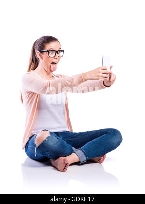 Smartphone avec femme assise sur le sol, isoler, studio shot Banque D'Images