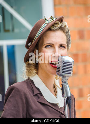 Woodhall Spa 1940 Festival - femme en robe traditionnelle des années 40, chantant Banque D'Images