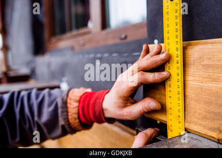 Main de méconnaissable, travailleur faisant façade, measuring wooden bo Banque D'Images