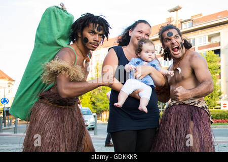 Mère avec un jeune bébé posant pour une photo de groupe avec deux membres de l'UDV Dance Company de Suva, Fidji, au 28ème Festival de Folklore CIOFF international Folkart, folklore sous-festival Festival de Carême, l'un des plus grands festivals en plein air en Europe. Folkart, Festival le Carême, Maribor, Slovénie, 2016. Banque D'Images