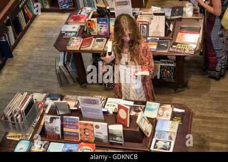 Jeune femme recherche de livres à la librairie Housing Works à Soho, New York City Banque D'Images
