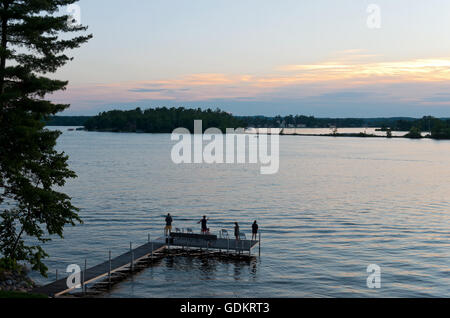 Pier avec des gens comme pêche coucher de soleil sur la baie de vapeur et de Birch Island East Gull Lake dans le comté de Cass minnesota en dehors de brai Banque D'Images