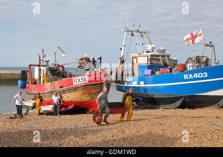 Pêcheurs de Hastings déchargeant du poisson sur la plage du Stade, East Sussex, Angleterre, bateaux de pêche britanniques Banque D'Images
