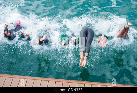 Les triathlètes féminines de plonger dans la mer au début de triathlon. Banque D'Images