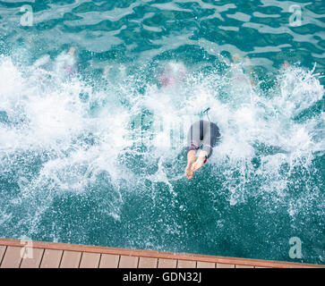 Les triathlètes féminines de plonger dans la mer au début de triathlon. Banque D'Images