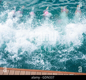 Les triathlètes féminines de plonger dans la mer au début de triathlon. Banque D'Images