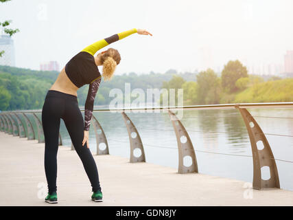 Jeune fille sportive doing stretching dans city park Banque D'Images