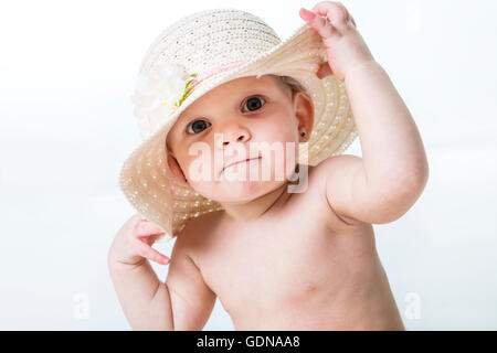 Baby Girl montrant portant un chapeau isolé sur fond blanc Banque D'Images