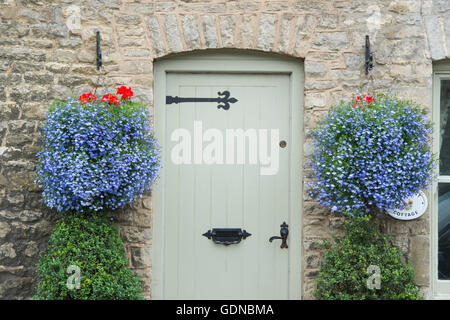 Lobelia 'techno blue' paniers suspendus à l'extérieur d'un chalet à Stow on the Wold, Cotswolds, Gloucestershire, Angleterre Banque D'Images