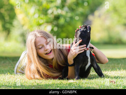 Jeune jolie fille avec chiot bouledogue français Banque D'Images