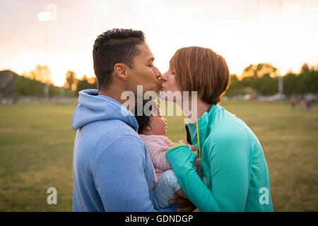 Couple avec bébé, kissing in park Banque D'Images