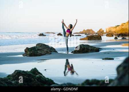 Jeune femme ballerine en équilibre sur une jambe sur beach, Los Angeles, Californie, USA Banque D'Images
